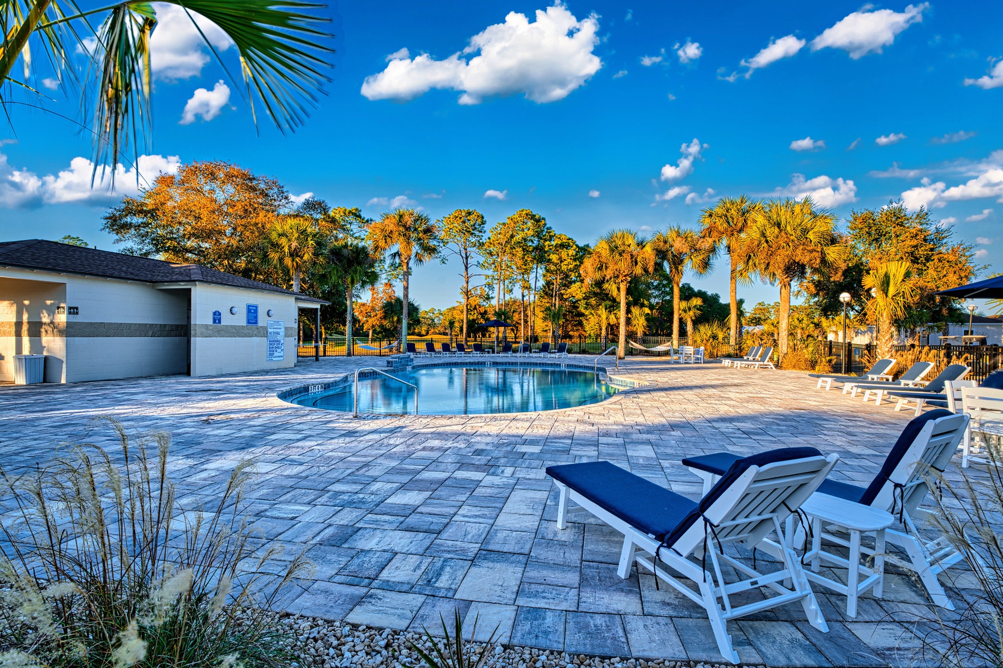 Lounge chairs beside the resort pool under a blue sky at St. James Bay